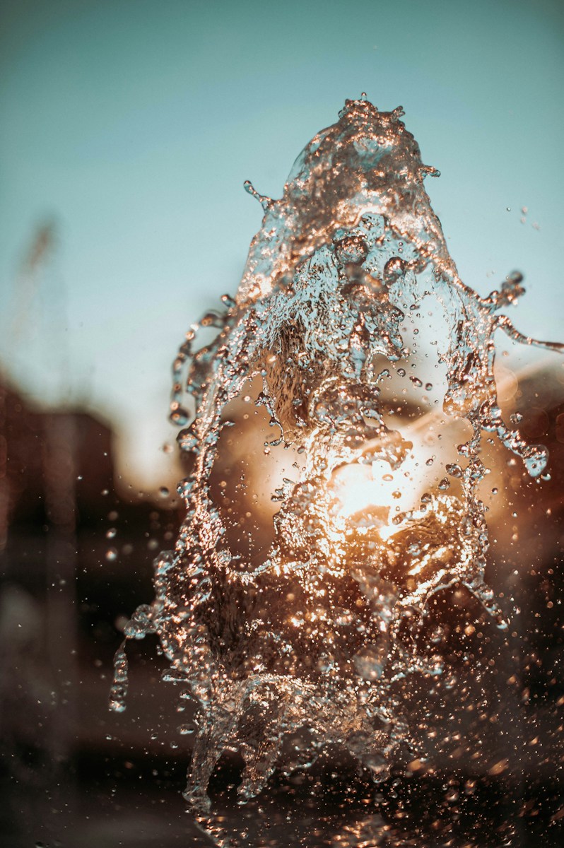 a close up of a water fountain with a blue sky in the background