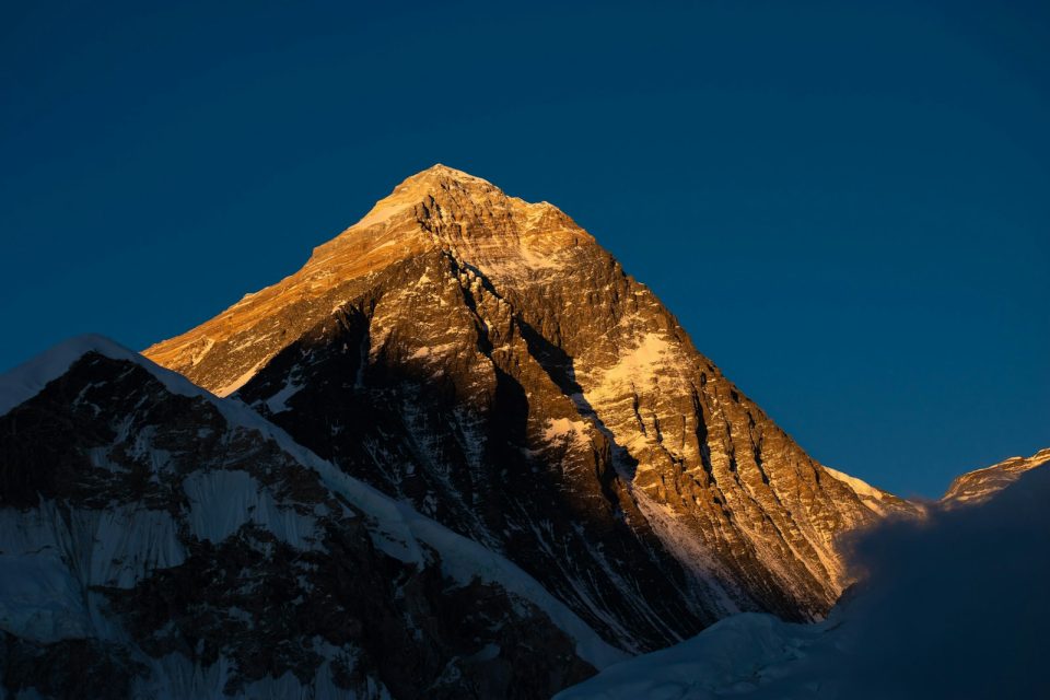 a snow covered mountain with the sun shining on it
