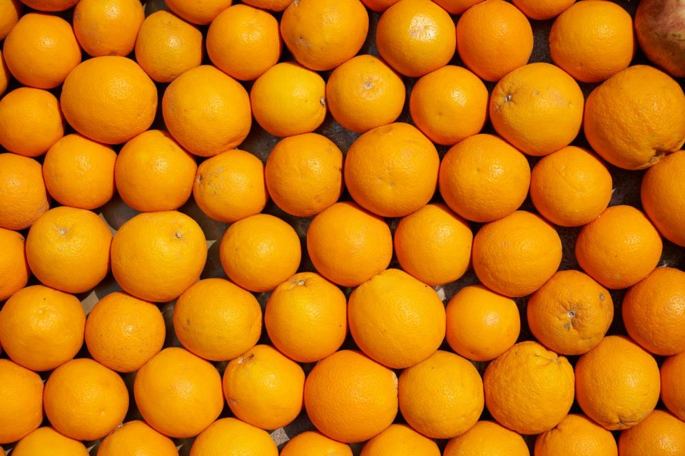 A top view of vibrant oranges neatly arranged, showcasing freshness and juiciness.
