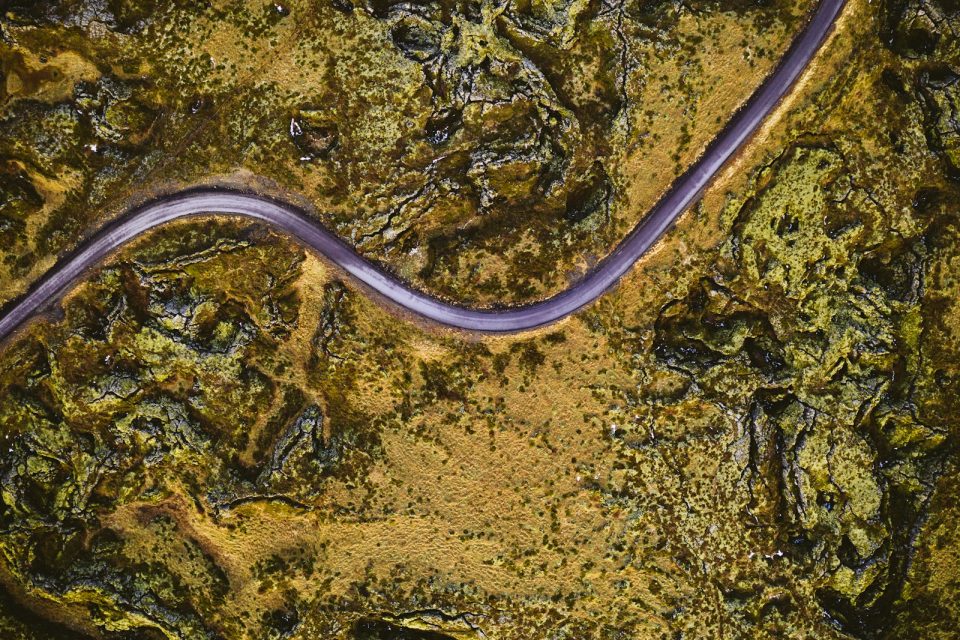 an aerial view of a road in the middle of a field
