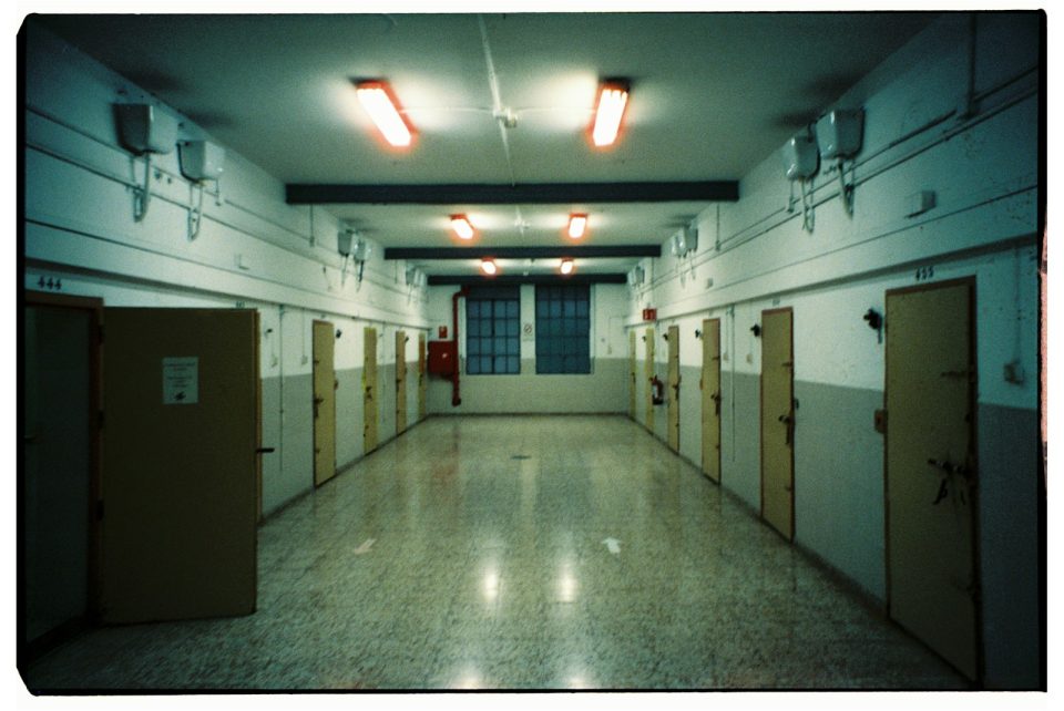 A long hallway with several doors and lights