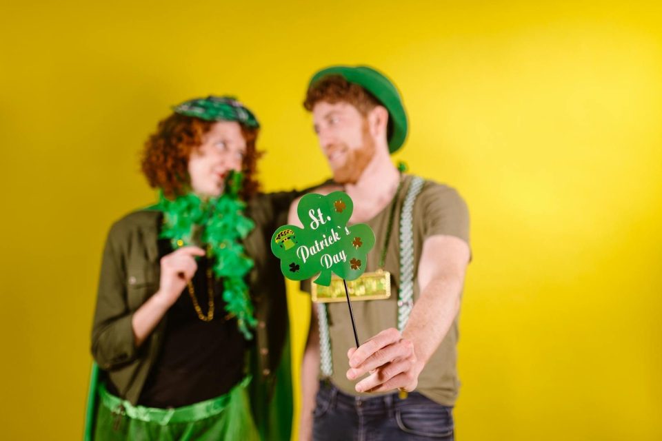 Happy couple celebrating St. Patrick's Day with costumes and props.