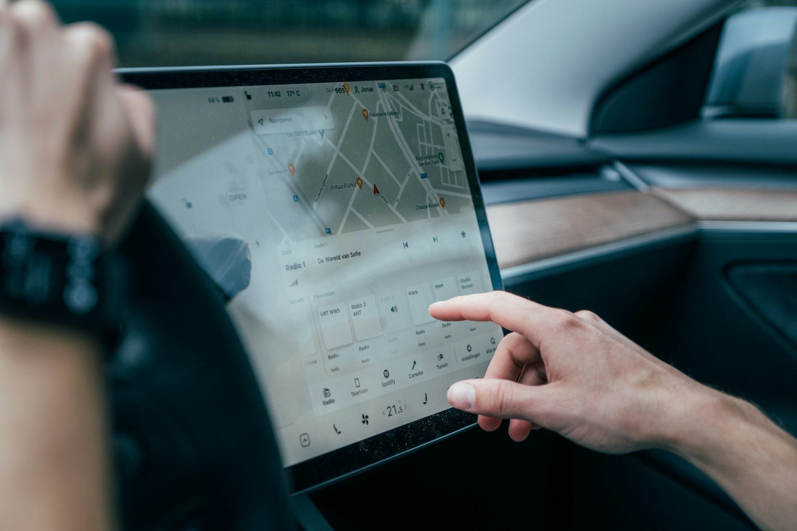 Photo by Jonas Leupe a person using a laptop in a car