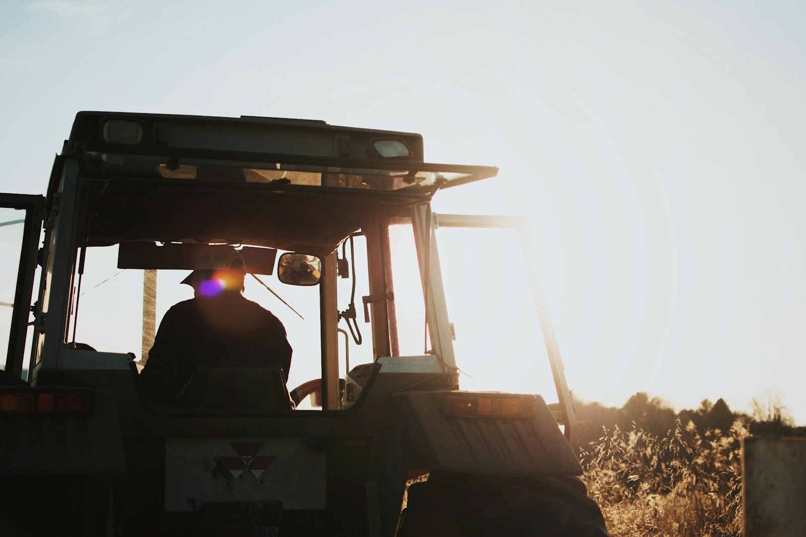 Photo by Spencer Scott Pugh silhouette of man riding tractor