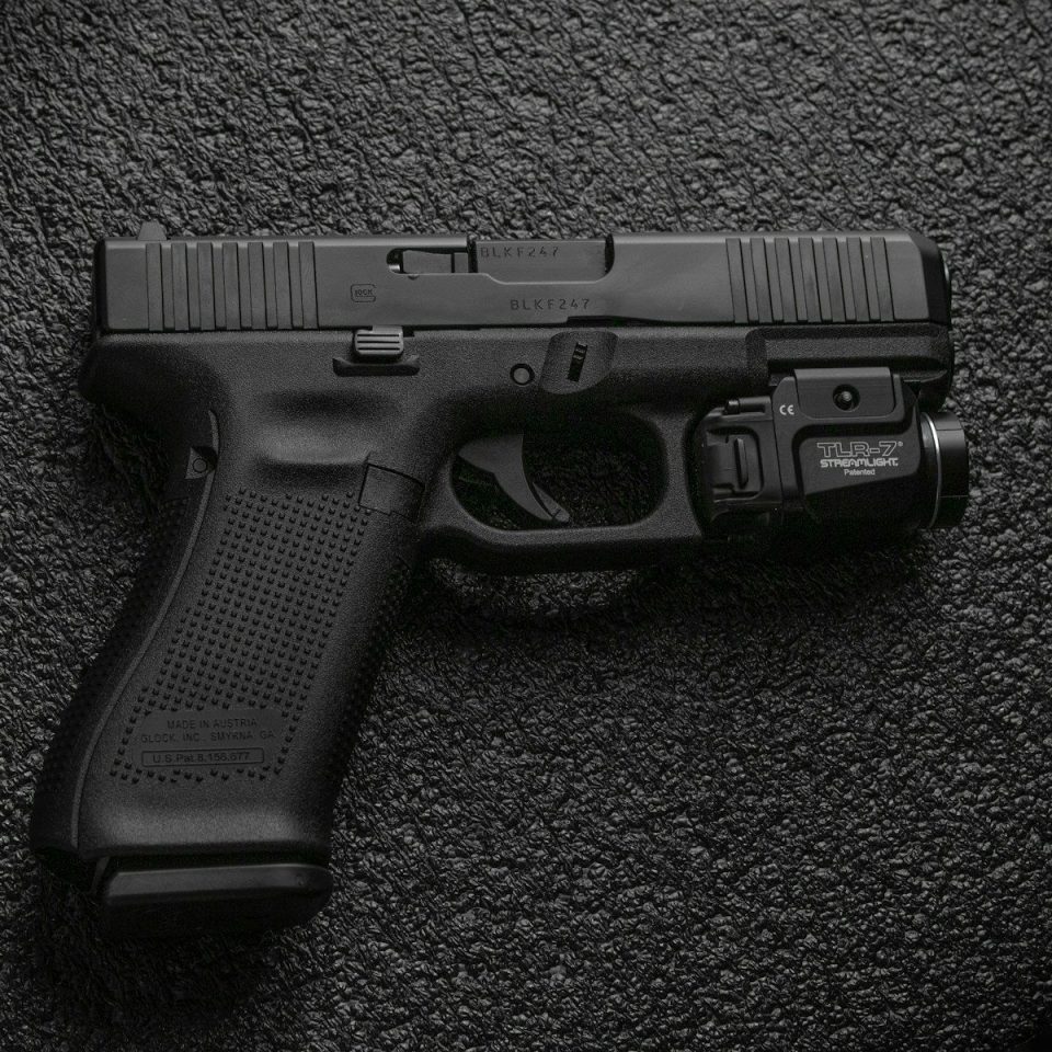 black semi automatic pistol on gray textile