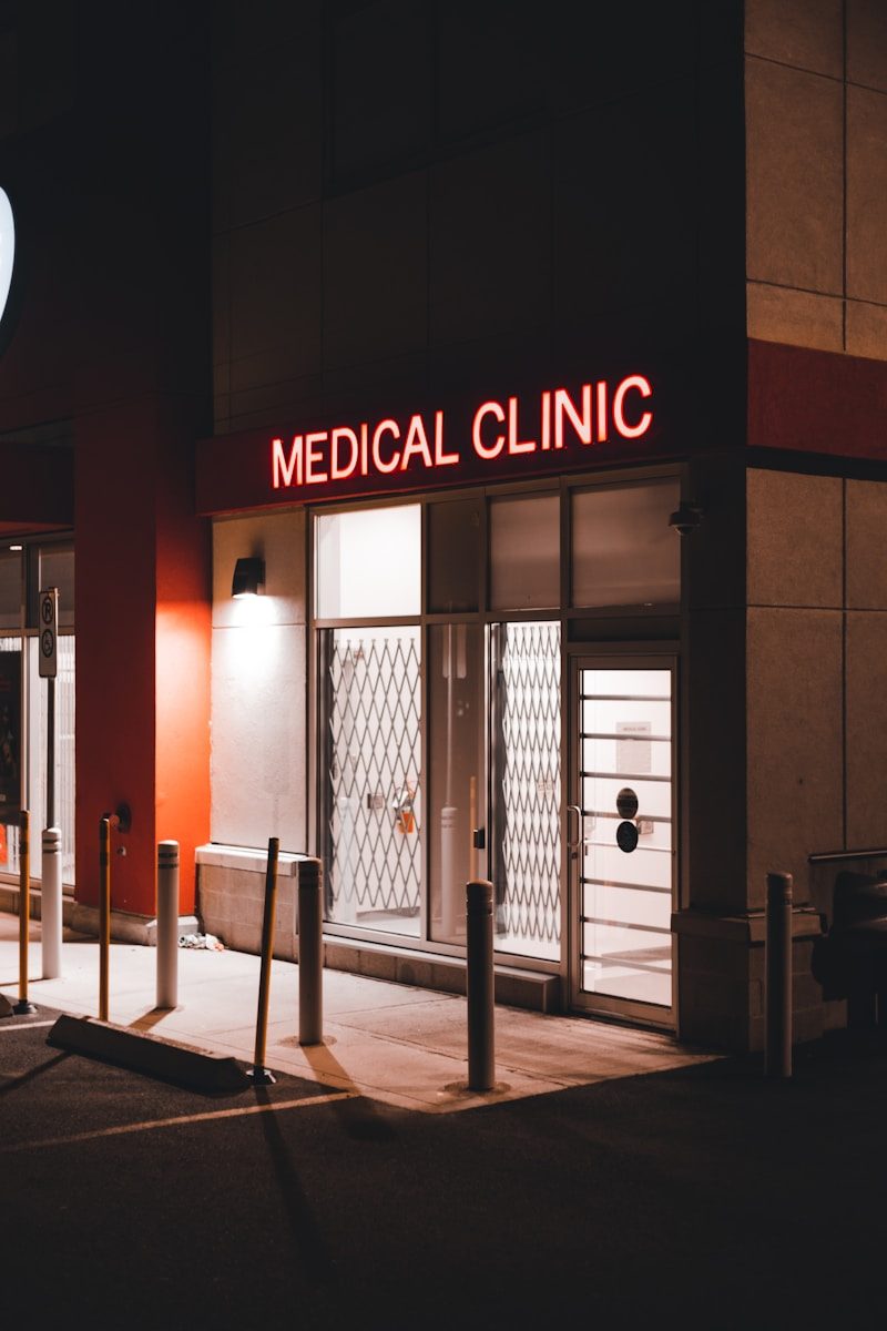 a medical clinic at night with a neon sign