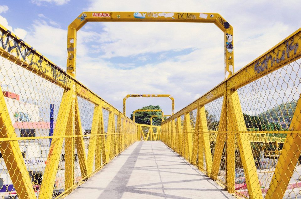 a yellow metal bridge with a yellow gate