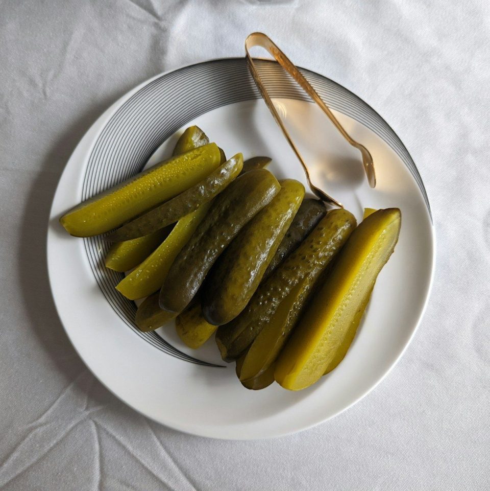 a white plate topped with pickles next to a fork