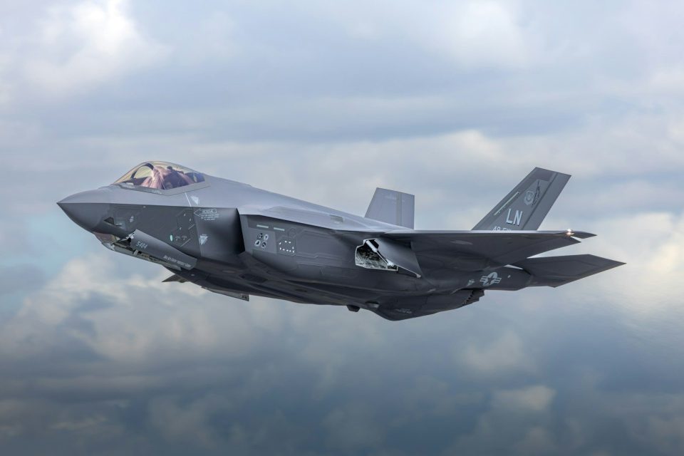 a fighter jet flying through a cloudy sky