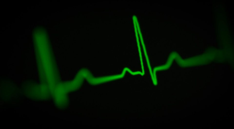 a green heart beat on a black background