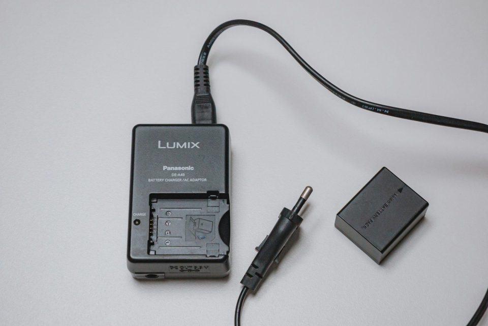 A lumix battery charger with a battery and plug
